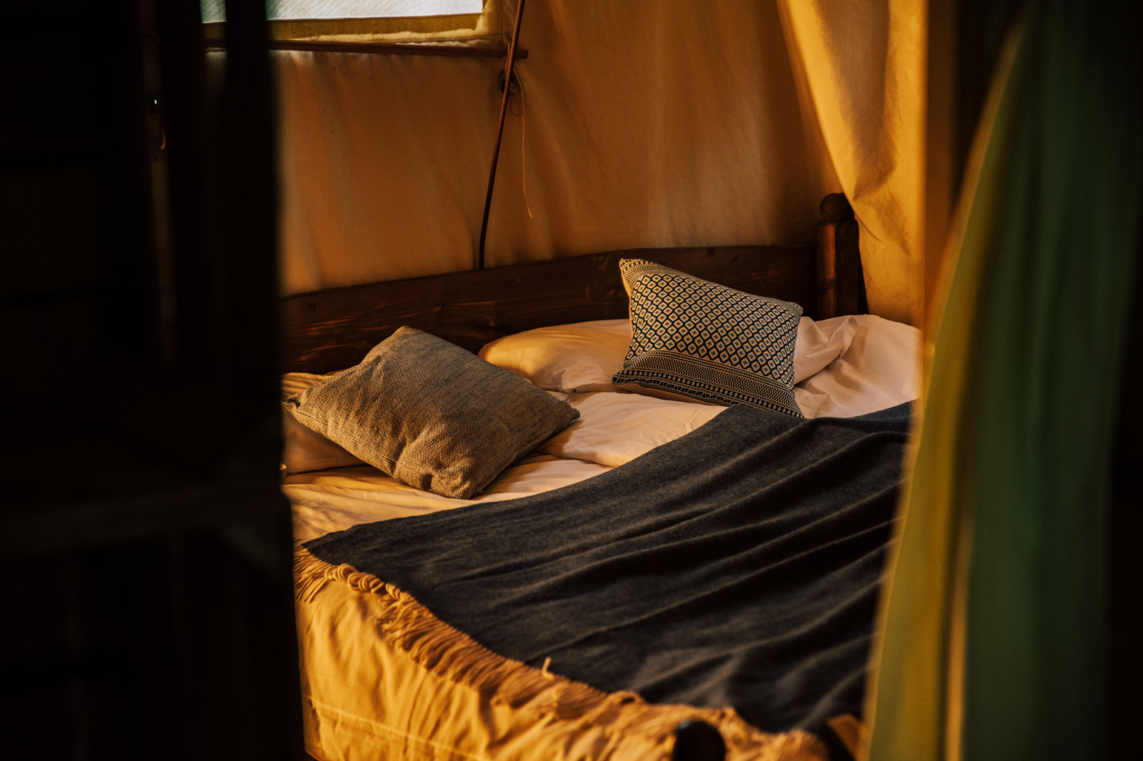 Knusse slaaphoek in safaritent Tent house met een eigen warme douche vlak naast de tent.