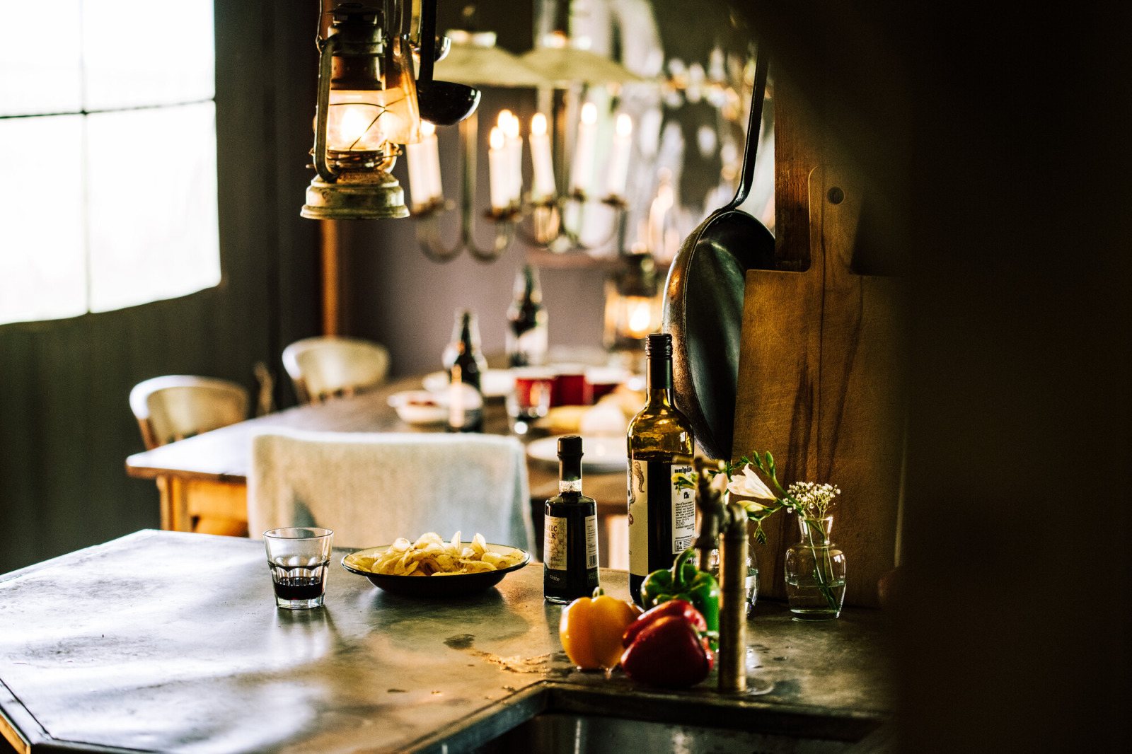 Gezellige safaritent met rustieke keuken, verse groenten, wijnflessen en warme sfeerverlichting.