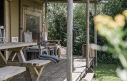Veranda in legno con sedute rustiche al Beach Lodge Luxury, Duynpark Het Zwanenwater, Paesi Bassi.