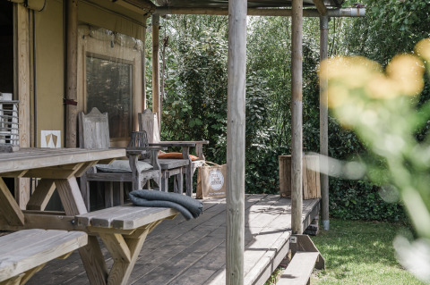 Wooden porch with rustic seating at Beach Lodge Luxury, Duynpark Het Zwanenwater, Netherlands.