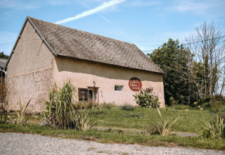 Et traditionelt hus med skråt tag og have ved Feather Down Ô manoir de Glams feriepark i Normandiet, Frankrig.