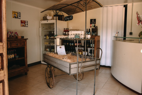 Un rincón rústico de tienda en Feather Down Ô manoir de Glams con huevos, bebidas y productos locales.