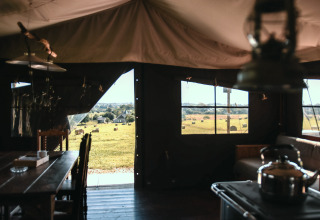 Vista dall'interno di una tenda a Feather Down Ô manoir de Glams in Normandia, Francia, su campi e balle di fieno.