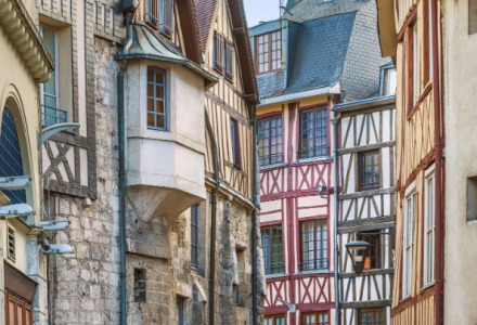 Callejón estrecho con casas de entramado de madera y muros de piedra en Isigny-le-Buat, Normandía, Francia.