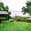 A family sits at a picnic table on the grass at Feather Down Lunsford Farm holiday park in Southeast England, UK.