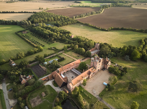 Vue aérienne de Feather Down Layer Marney Tower, parc de vacances dans l’Est de l’Angleterre entouré de champs.