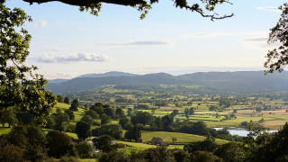 Vista panorámica de campos verdes y colinas en Feather Down Pant y March Farm, parque vacacional en Gales, Reino Unido.