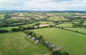 Vista aérea de Feather Down Billingsmoor Farm, un parque vacacional rodeado de campos verdes en el suroeste de Inglaterra.
