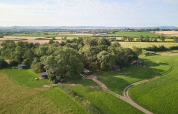 Vista aérea del parque vacacional Feather Down Moor Farm en el suroeste de Inglaterra, rodeado de campos.
