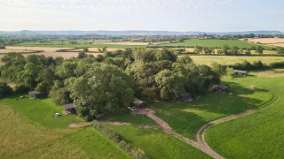 Luchtfoto van vakantiepark Feather Down Moor Farm in Zuidwest-Engeland, met hutten en groene velden.