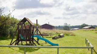 Aire de jeux avec balançoires et toboggan au parc de vacances Feather Down College Farm dans l’Est de l’Angleterre.