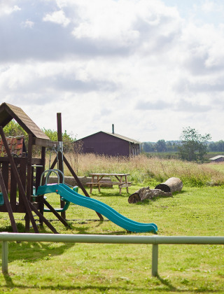 Aire de jeux avec balançoires et toboggan au parc de vacances Feather Down College Farm dans l’Est de l’Angleterre.