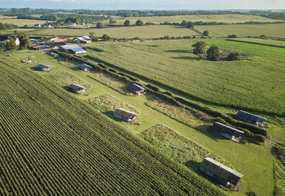 Luchtfoto van Feather Down College Farm vakantiepark met tenten en velden in Oost-Engeland, Verenigd Koninkrijk.