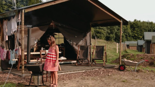 Meisje in rood gestreepte jurk kookt bij safaritent met privé douche bij Feather Down Fermette des trois tilleuls, Frankrijk.