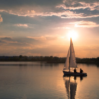 Dos personas navegan en un lago tranquilo al atardecer cerca de Penzance, Suroeste de Inglaterra, Reino Unido.