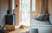 Interior of Gipsy wagon with terrace at Camping Papillon in Belgium, cozy modern decor and large windows.
