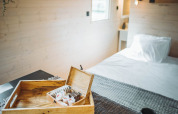 Sfeervol interieur van de Gipsy wagon met houten wanden, dienblad, plantje en gezellig bed.