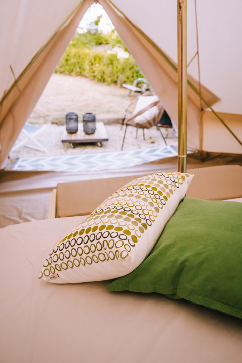 Binnen in een Bell-tent bij Agriturismo Angeli Sognanti in Italië, kussens en een gezellige buitenzicht.