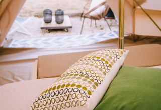 Dentro una tenda Bell presso Agriturismo Angeli Sognanti in Italia, con cuscini e vista rilassante fuori.