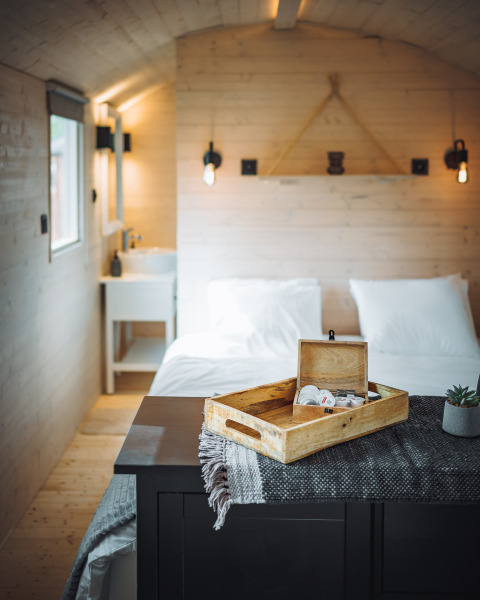 Acogedor interior de la cabaña Pipowagen en Camping Papillon, Bélgica, con paredes de madera y cama doble.