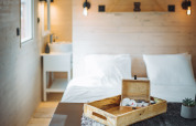 Intérieur cosy de la cabane Pipowagen au Camping Papillon en Belgique, avec murs en bois et lit double.