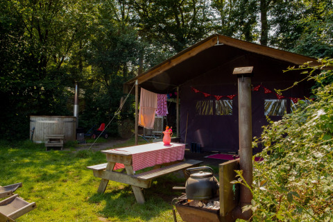 Tenda glamping accogliente con tavolo da picnic, braciere e vista naturale al Feather Down Het Wesselink in Salland.