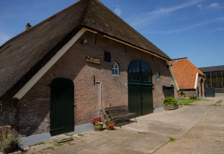 Edificio tradizionale con tetto di paglia a Feather Down Het Wesselink a Salland, parco vacanze a Overijssel.