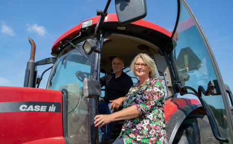 Due persone accanto a un trattore rosso CASE IH sotto il sole a Feather Down Het Wesselink a Salland, Overijssel.