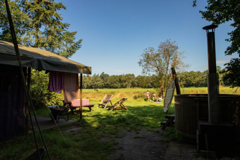 Vista de un campamento con sillas y pradera en Feather Down Het Wesselink en Salland, Overijssel, Países Bajos.