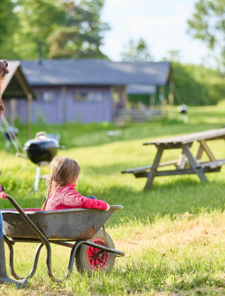 En mor skubber et barn i en trillebør på Feather Down Hidcote Manor Farm, en feriepark i West Midlands.