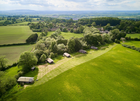 Aerial view of Feather Down Hidcote Manor Farm holiday park in West Midlands, UK, with fields and trees.