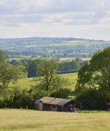 Billede af et sommerhus midt i det engelske landskab ved Feather Down Hidcote Manor Farm, West Midlands.