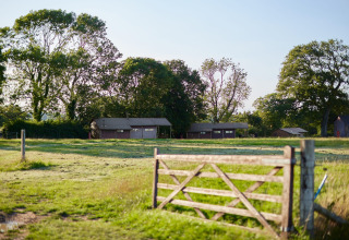 Feather Down Mount Pleasant vakantiepark in Zuidwest-Engeland met groene weide, houten poort en lodges.