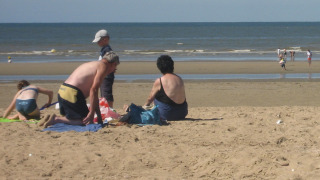 Famille profitant d'une journée ensoleillée sur la plage dans un parc de vacances avec glamping.