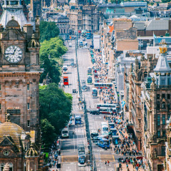 Udsigt over en travl bygade med ikonisk klokketårn og historisk arkitektur i Skotland, Storbritannien.