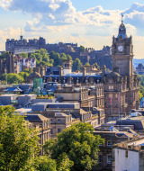 Udsigt over Edinburghs skyline med det historiske slot og berømte vartegn på en solskinsdag i Skotland.