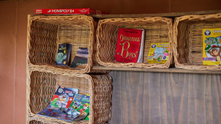 Flettede kurve med børnebøger og spil, inklusive Monopoly, i Feather Down Chesters feriepark, England.