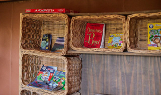 Flettede kurve med børnebøger og spil, inklusive Monopoly, i Feather Down Chesters feriepark, England.