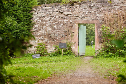 Muro de piedra con puerta abierta en Feather Down Chesters, parque vacacional en el noroeste de Inglaterra.