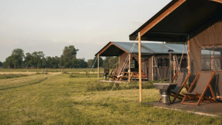 Safari-telt med private brusere ved Feather Down Botterheerd i Nederlandene, omgivet af natur.