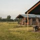 Safari-telt med private brusere ved Feather Down Botterheerd i Nederlandene, omgivet af natur.