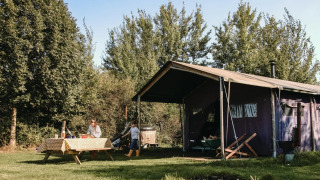 Safari tent at Feather Down De Kalverweide, Netherlands, with private hot shower and outdoor hot tub.