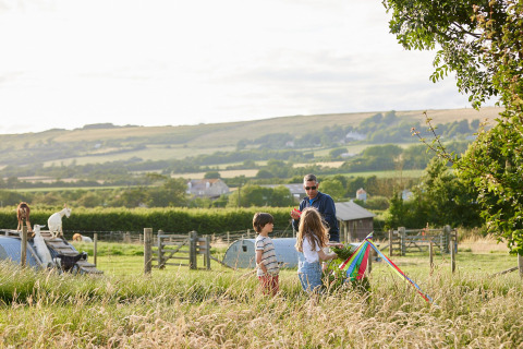 Familia juega con una cometa en un prado en el parque vacacional Feather Down East Shilvinghampton, Inglaterra.