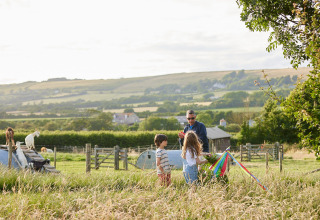 Familie leger med farverige bånd på en grøn mark i ferieparken Feather Down East Shilvinghampton, England.