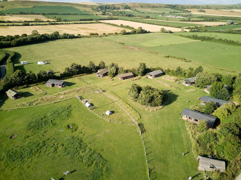 Vista aérea del parque vacacional Feather Down East Shilvinghampton en el suroeste de Inglaterra con campos verdes.