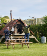 Deux hommes près d'une table de pique-nique et d'un four extérieur à Feather Down East Shilvinghampton.