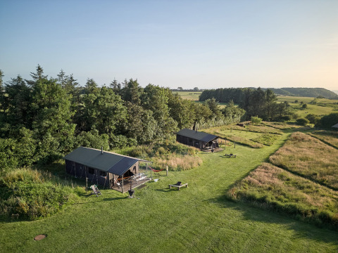 Twee tenten en groene natuur op Feather Down Warren Farm, een vakantiedomein in Zuidwest-Engeland.