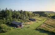 Two tents and green fields at Feather Down Warren Farm holiday park in Southwest England, United Kingdom.