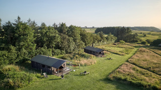 Twee tenten en groene velden bij Feather Down Warren Farm, een vakantiepark in Zuidwest-Engeland, VK.
