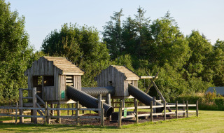 Legeområde af træ på Feather Down Warren Farm i det sydvestlige England med rør og legehuse.